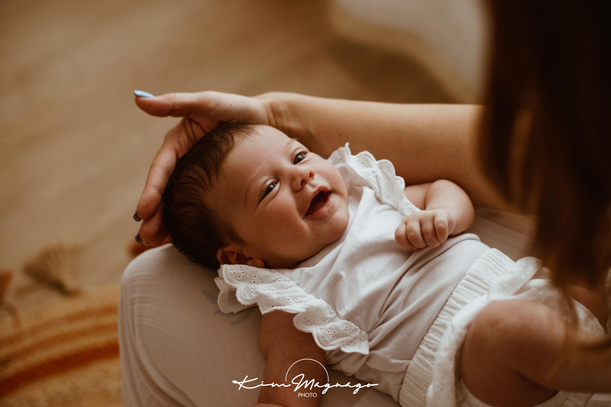 neonato sorride alla mamma in un servizio fotografico new born a Chioggia